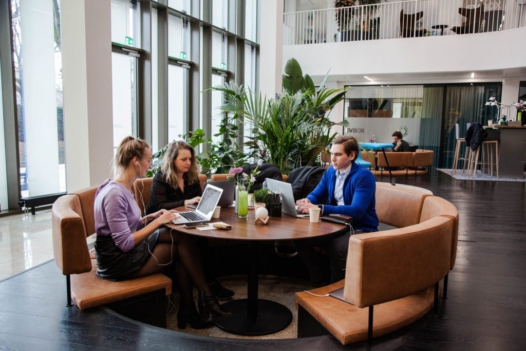 Mitarbeiter arbeiten in einem offenen, flexiblen Arbeitsbereich zusammen, der für hybride Arbeitsmodelle bei EDGE Workspaces konzipiert wurde.