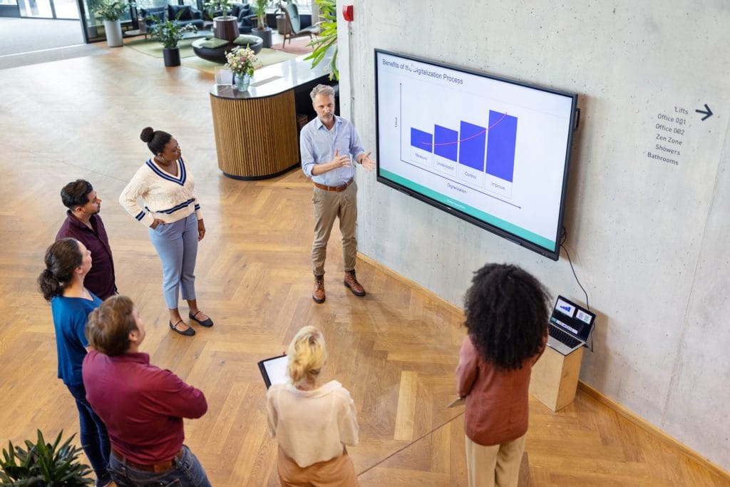 Das Team diskutiert bei EDGE Workspaces über KI-gesteuerte Dateneinblicke für die vorausschauende Wartung in modernen Büroräumen.