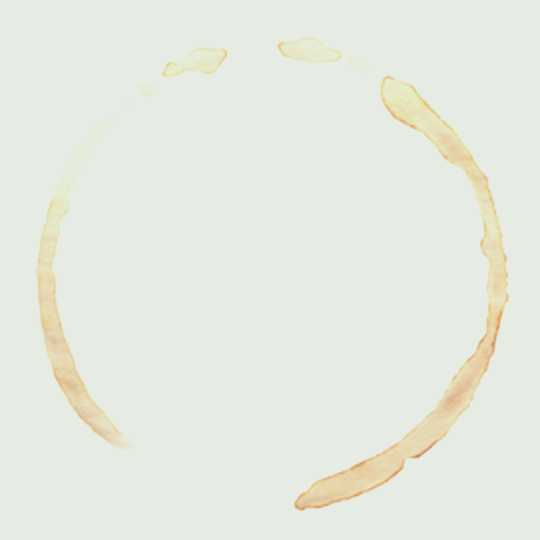 Das Bild zeigt einen hellbeigen Kaffeefleckring, kreisförmig mit ein paar kleinen Tropfen am oberen Rand, auf einem schlichten weißen Hintergrund. Der Fleck hat einen unebenen, leicht gewellten Rand. An image from EDGE Workspaces.